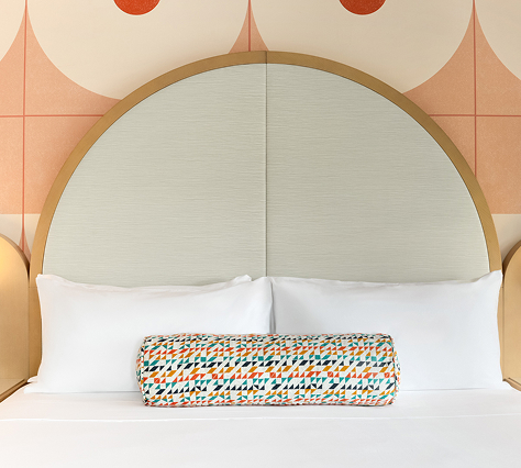 a bed with a round pillow on it
