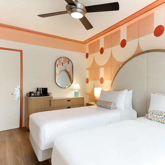 a room with two beds and a ceiling fan