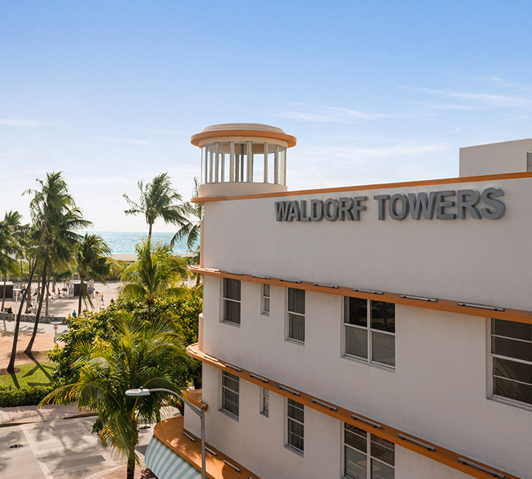a building with palm trees and a beach