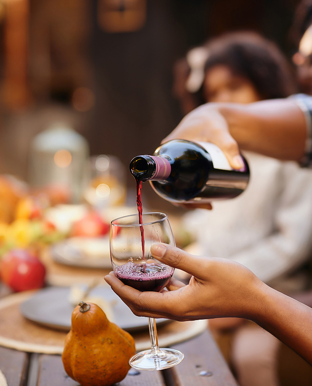a person pouring wine into a glass