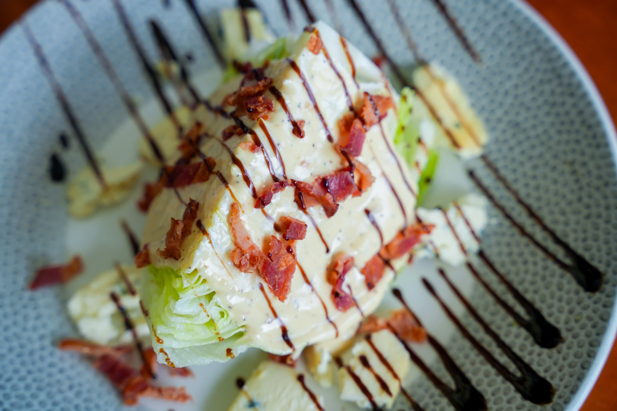 a salad with bacon and sauce on a plate