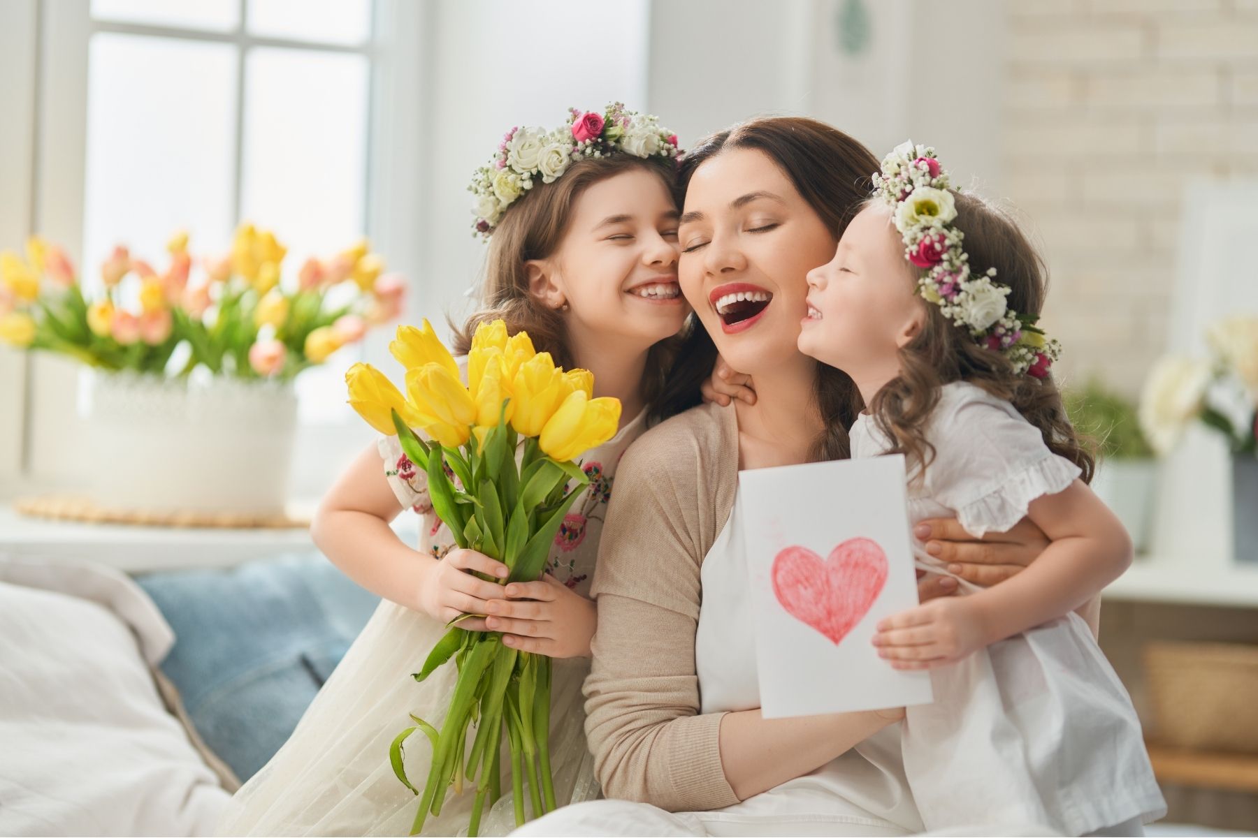 a woman and two girls with flowers on their heads