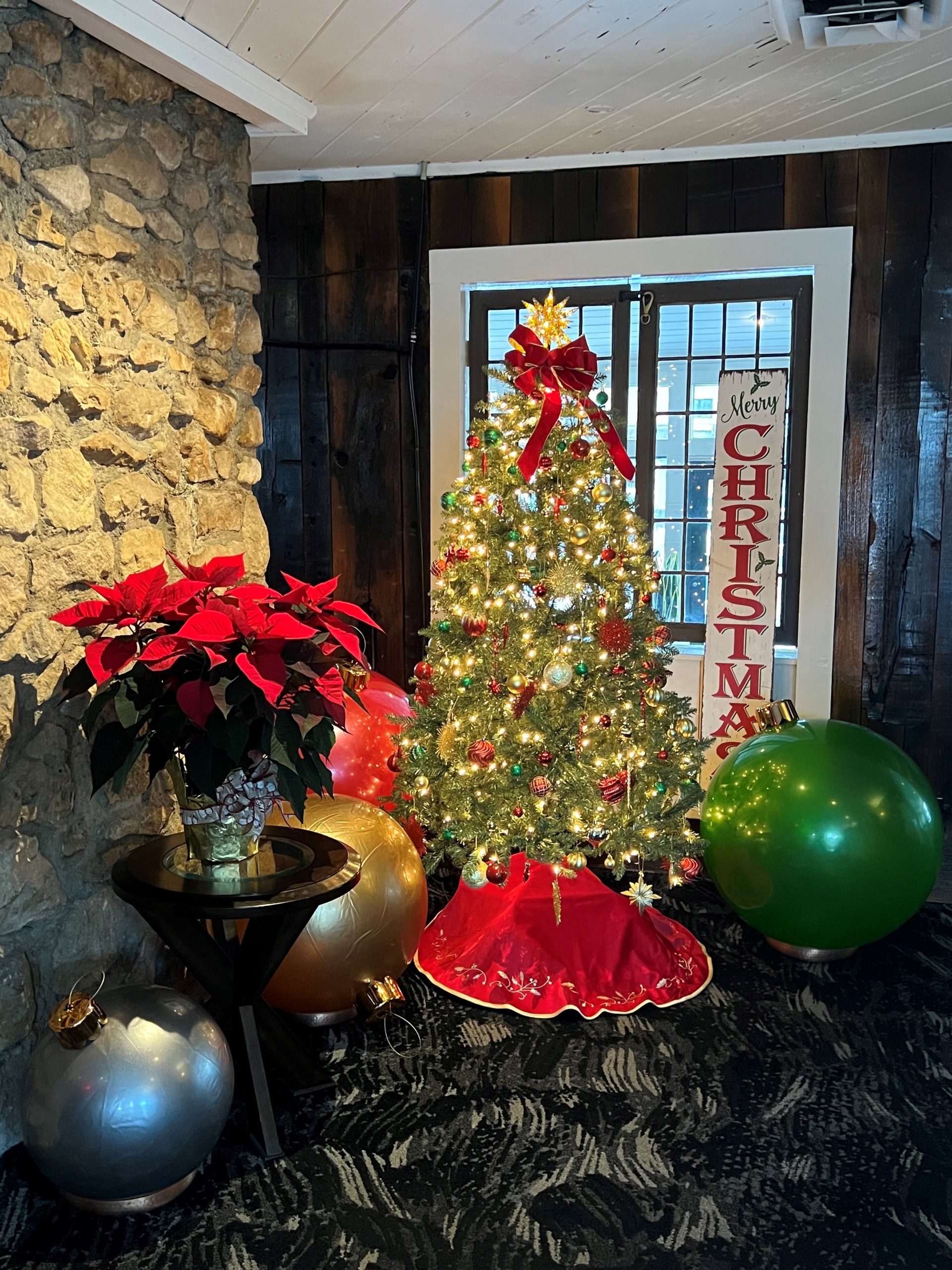 a christmas tree with lights and balloons