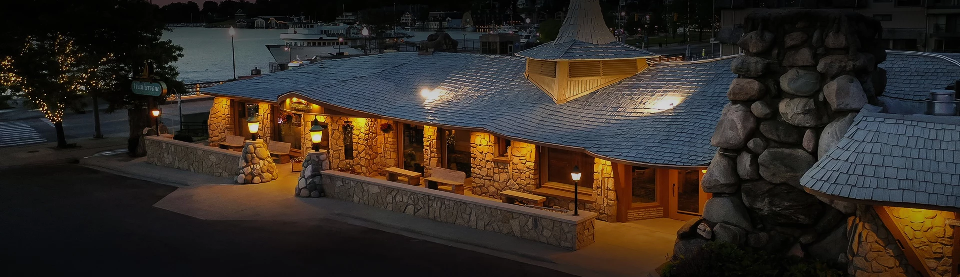 Exterior of Stafford's Weathervane Restaurant at 106 Pine River Lane in Charlevoix, Michigan, an Earl Young-designed former grist mill with curved stonework architecture