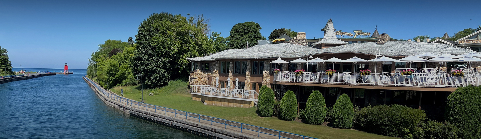 a building with a stone wall and a dock and trees