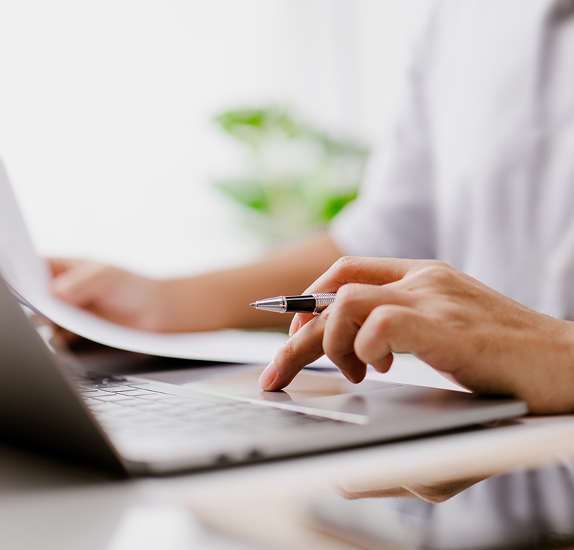 a person using a laptop and a pen