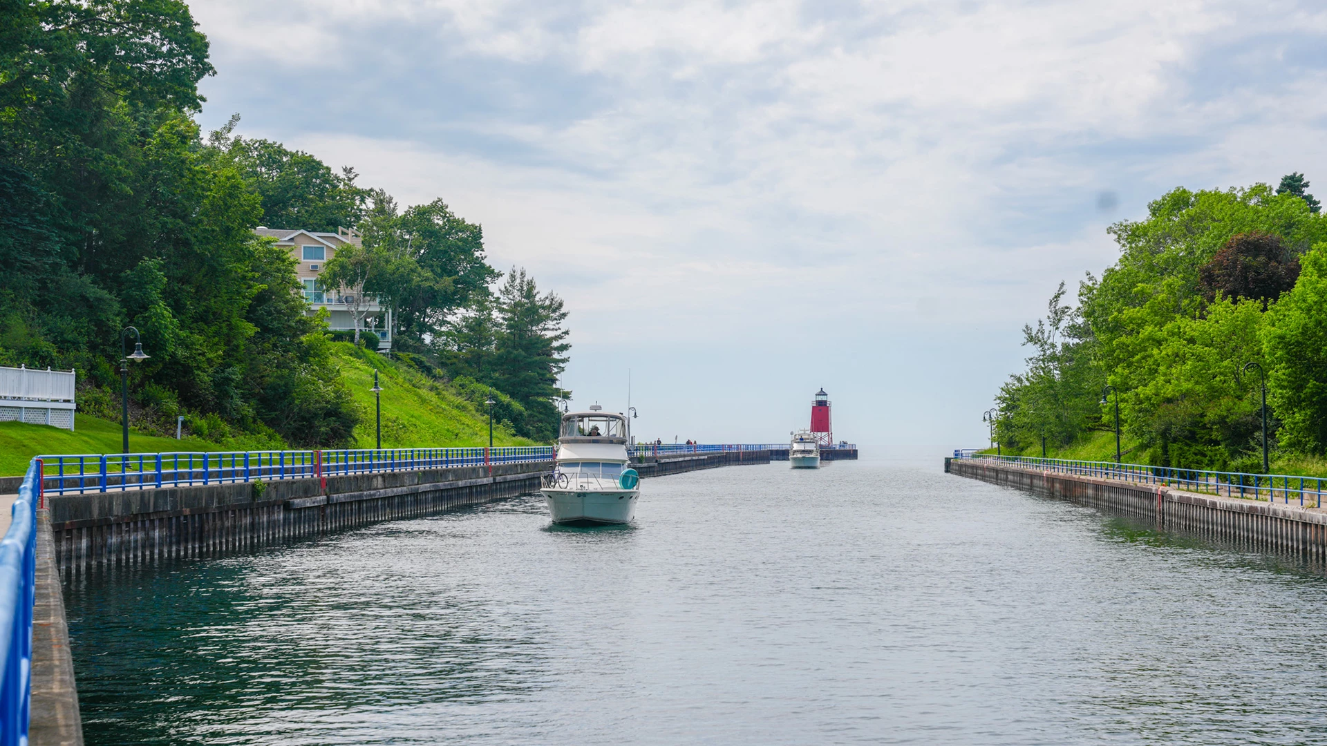 boats on a canal with a lighthouse and a boat