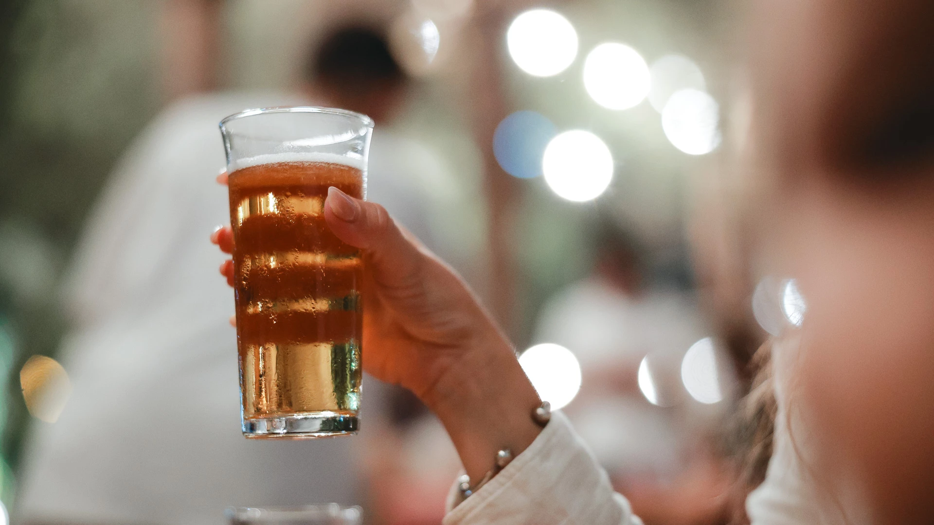 a hand holding a glass of beer