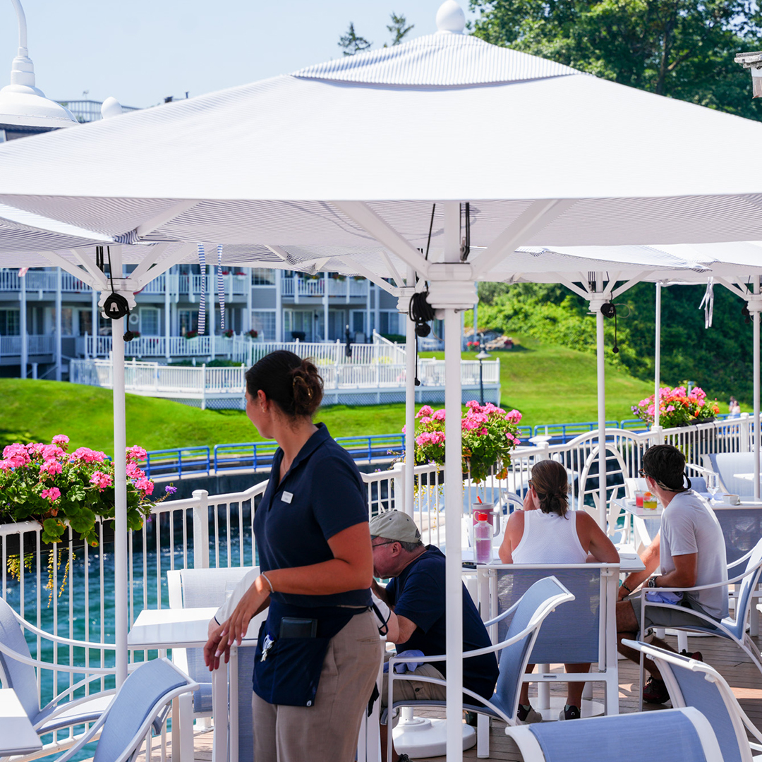 people sitting at a table under a white umbrella