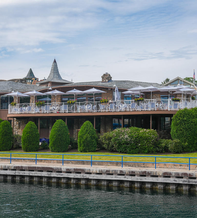 a building with a balcony and umbrellas by water