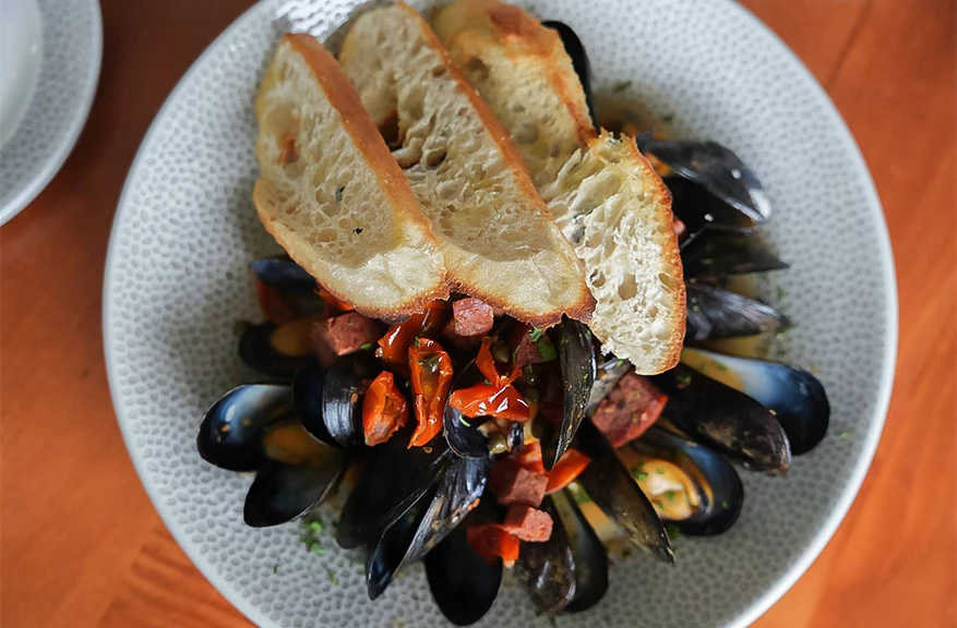 a plate of food with bread and mussels