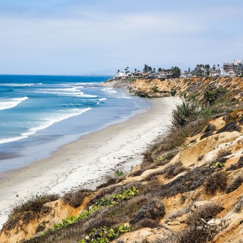 a beach with houses and waves