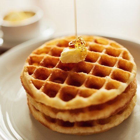 a stack of waffles with butter on top