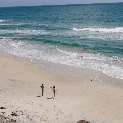 people on a beach with waves crashing on the shore