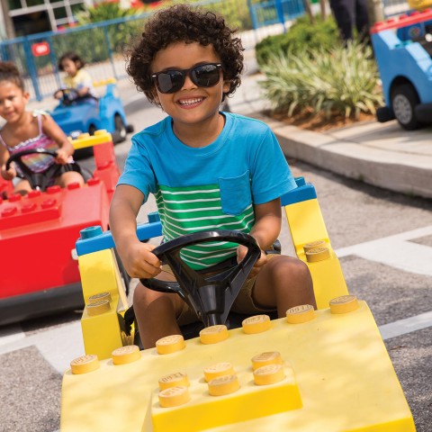 a boy driving a toy car
