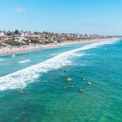 a beach with people swimming in the water