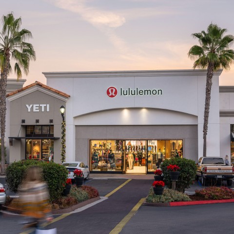 a building with palm trees and cars in front of it