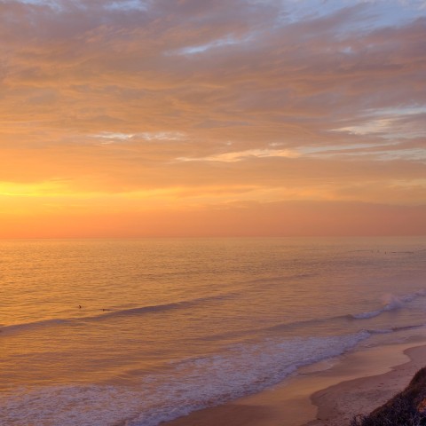 a beach with waves and a sunset