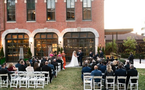 a couple getting married in front of a large brick building