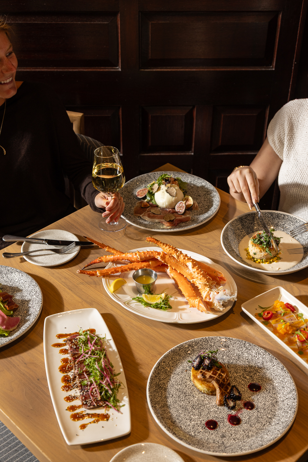 a group of people sitting at a table with plates of food