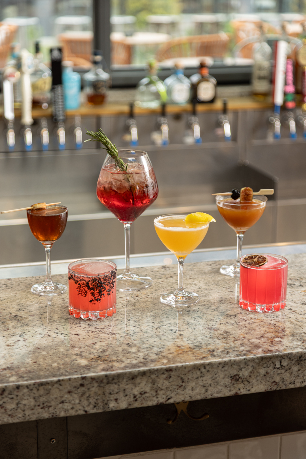 a group of different colored drinks on a counter