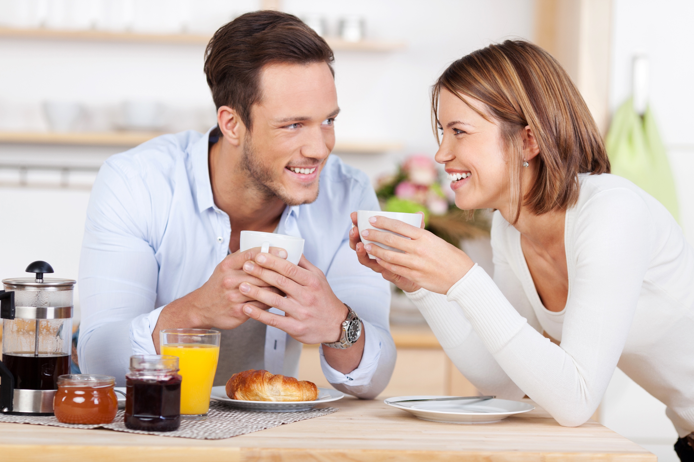 a man and woman holding cups of coffee