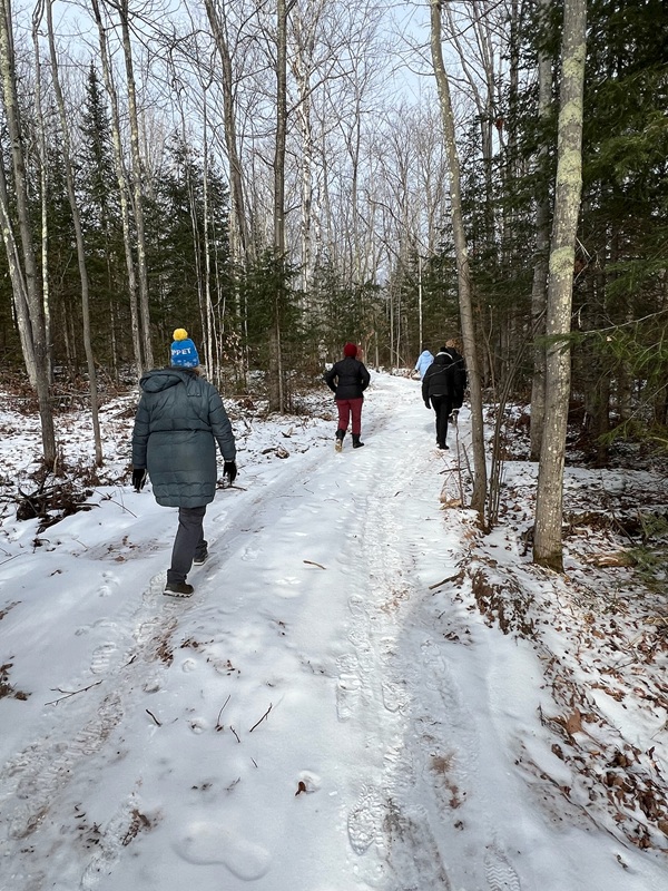 a group of people walking on a snowy path