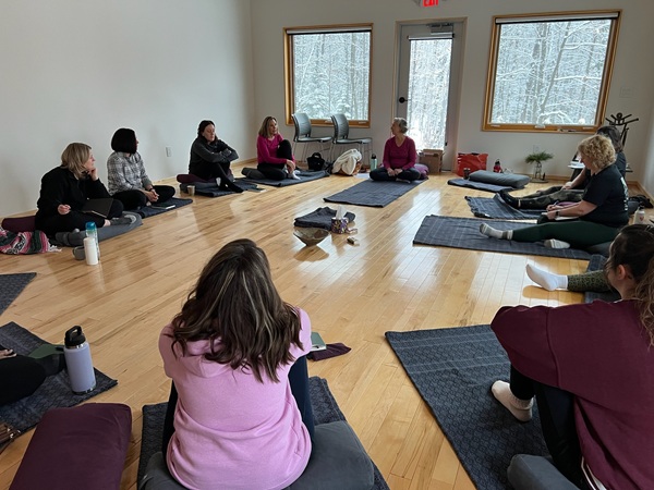 a group of people sitting on mats in a room