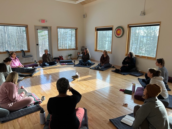 a group of people sitting on mats in a room