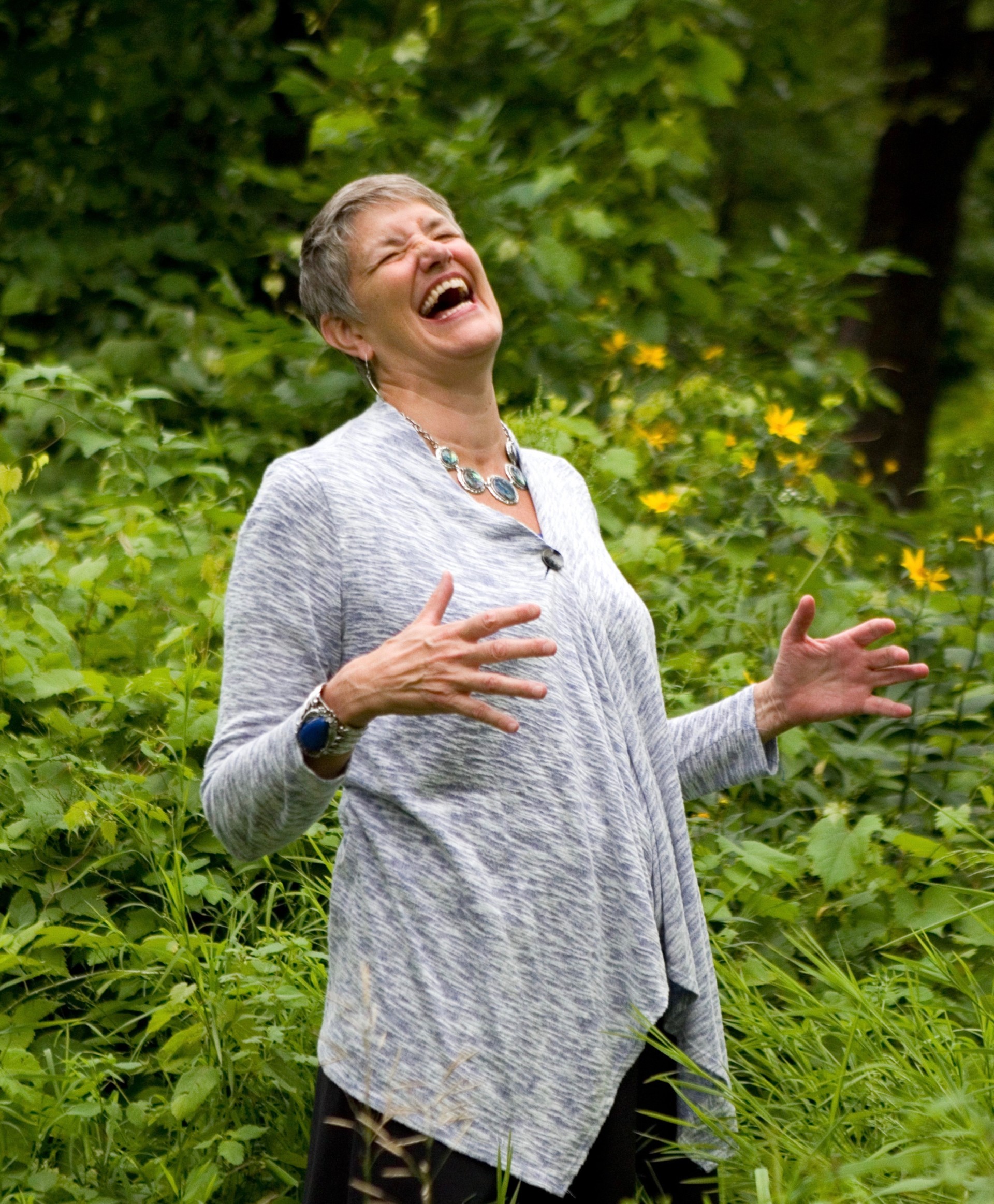 a woman laughing in the woods