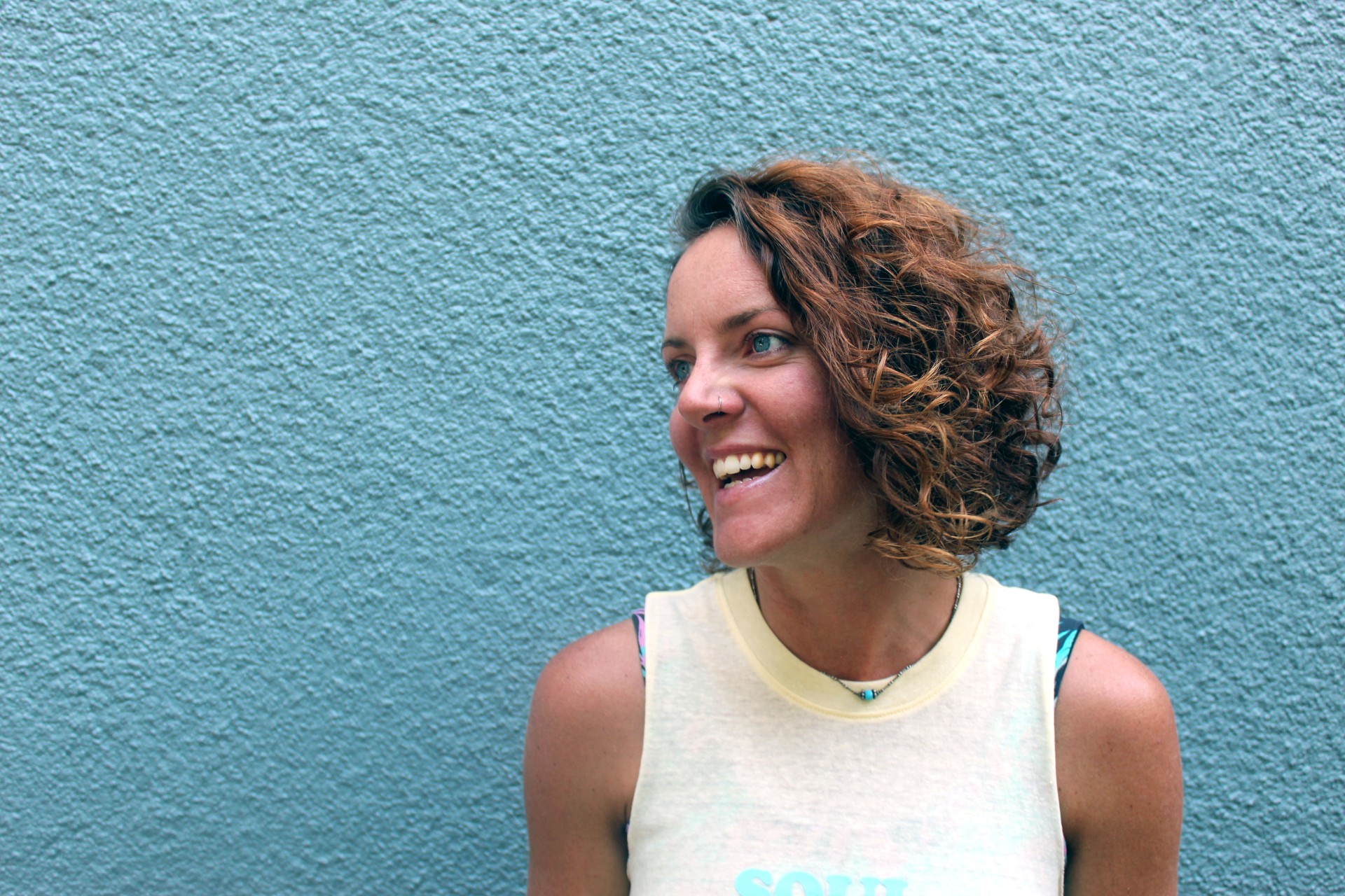 a woman smiling in front of a blue wall