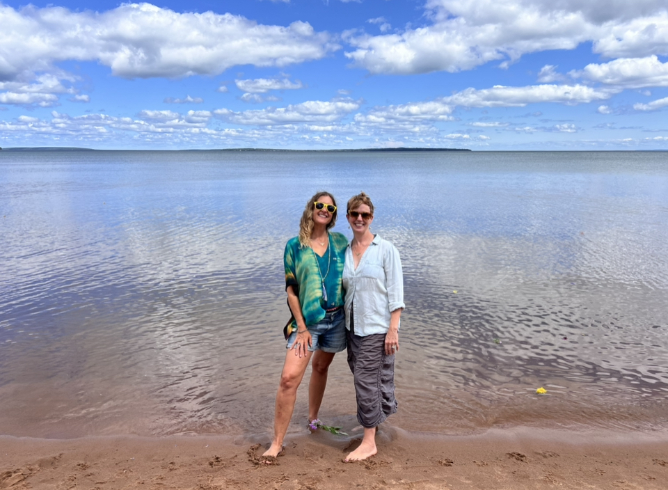 two women standing on a beach