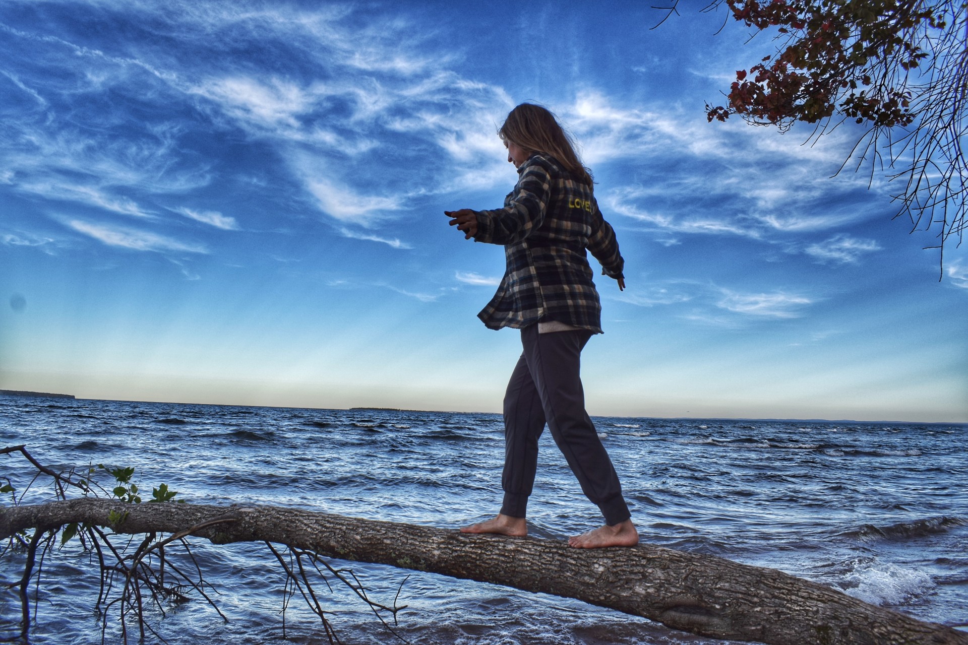 a woman walking on a log over water