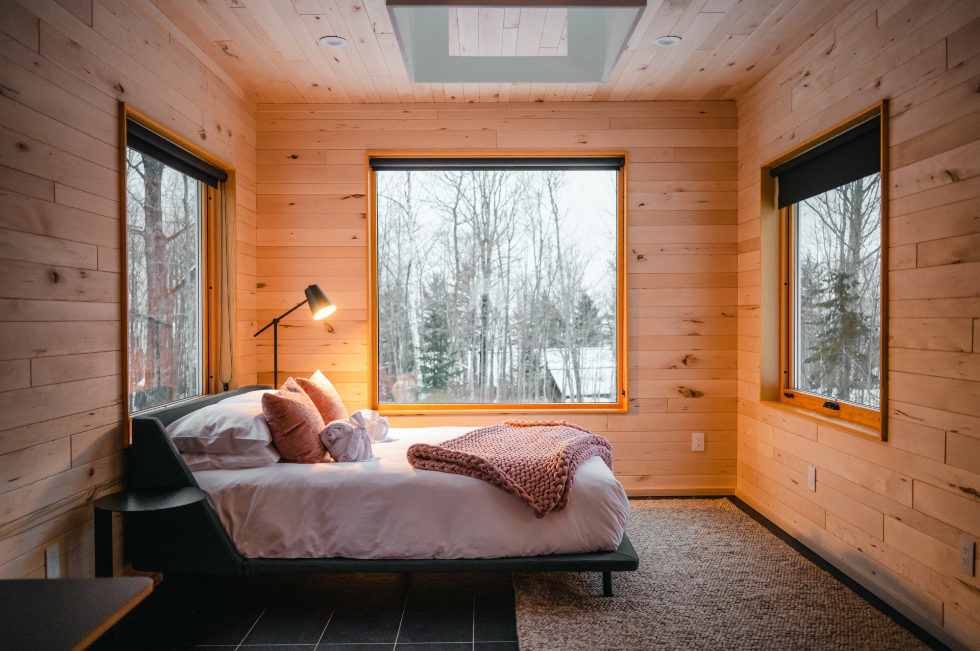 a bed in a room with windows