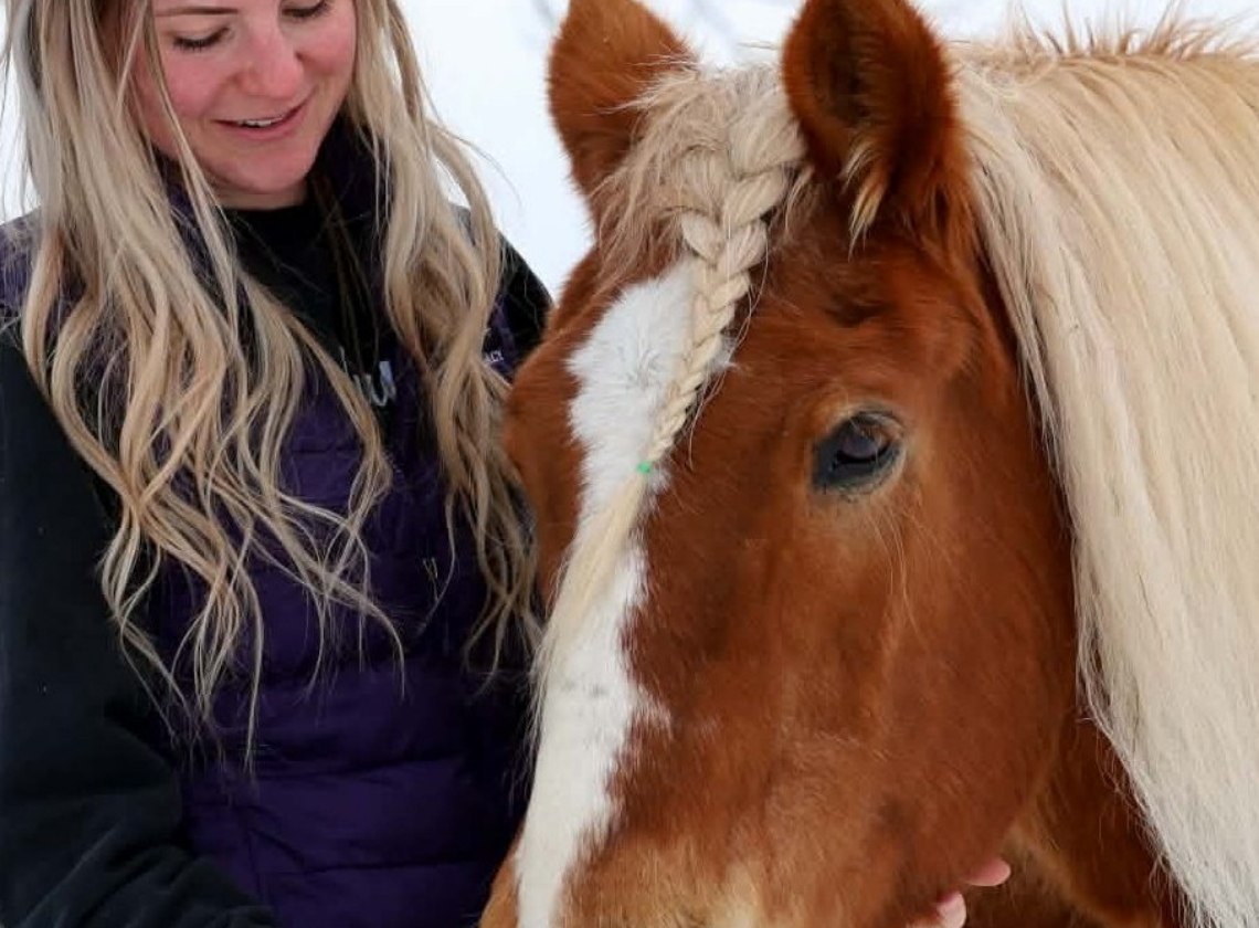 a woman petting a horse