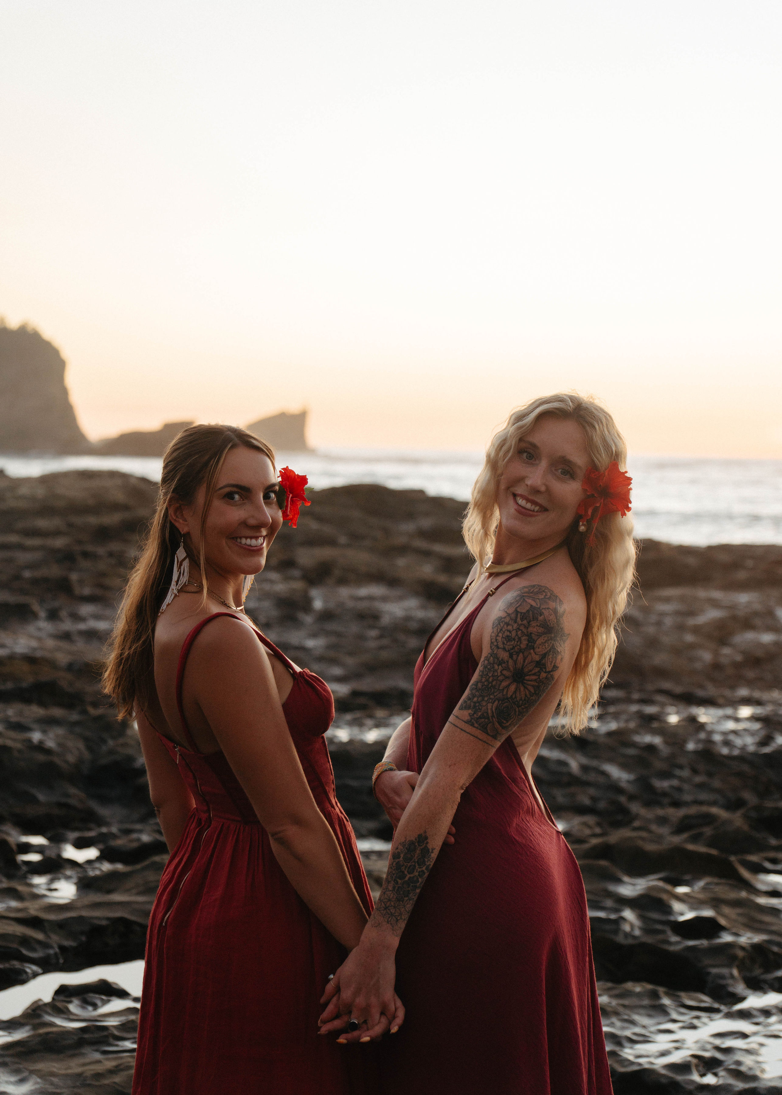 two women holding hands on a rocky beach