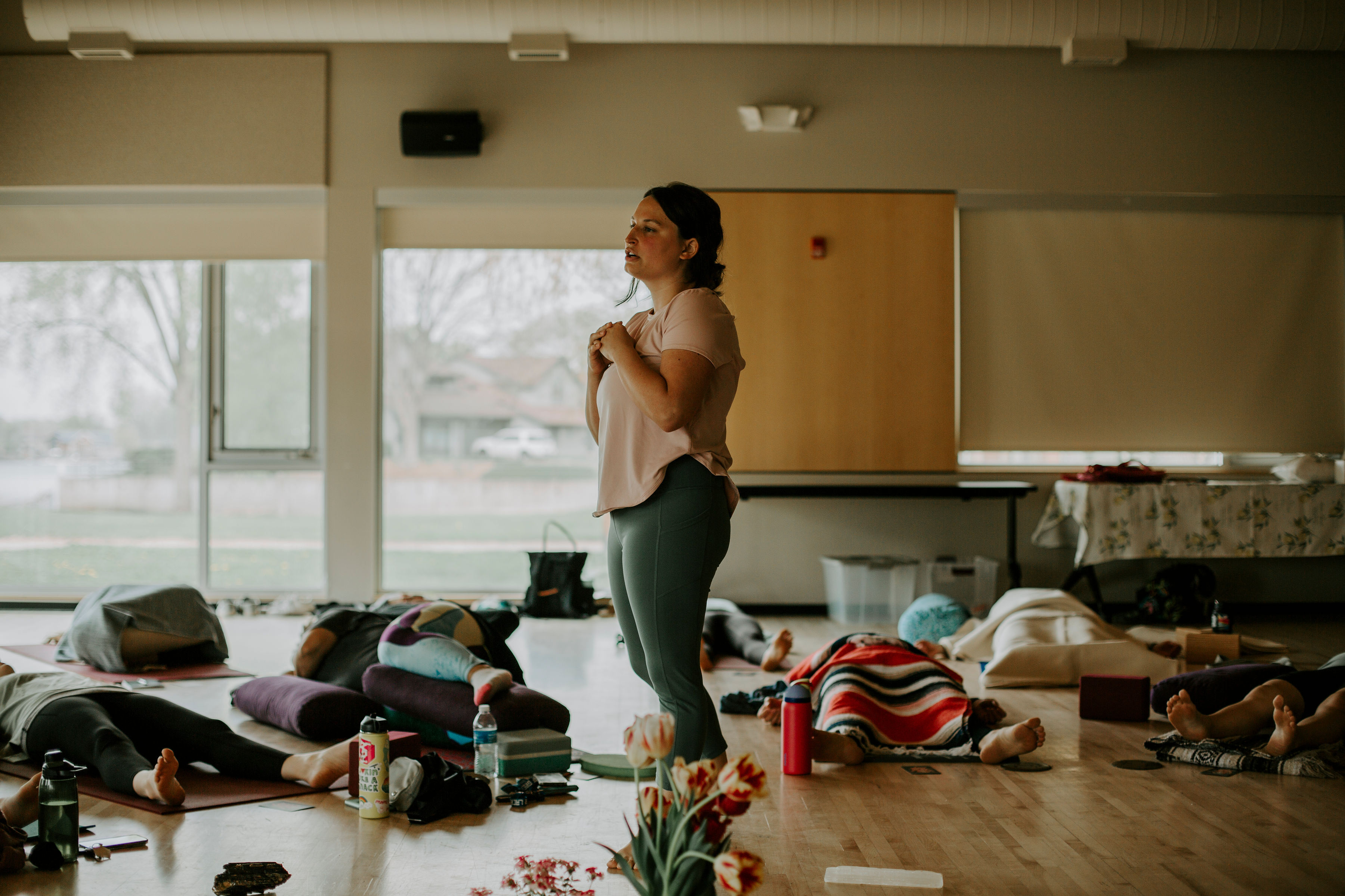 a woman standing in a room with other people lying on the floor