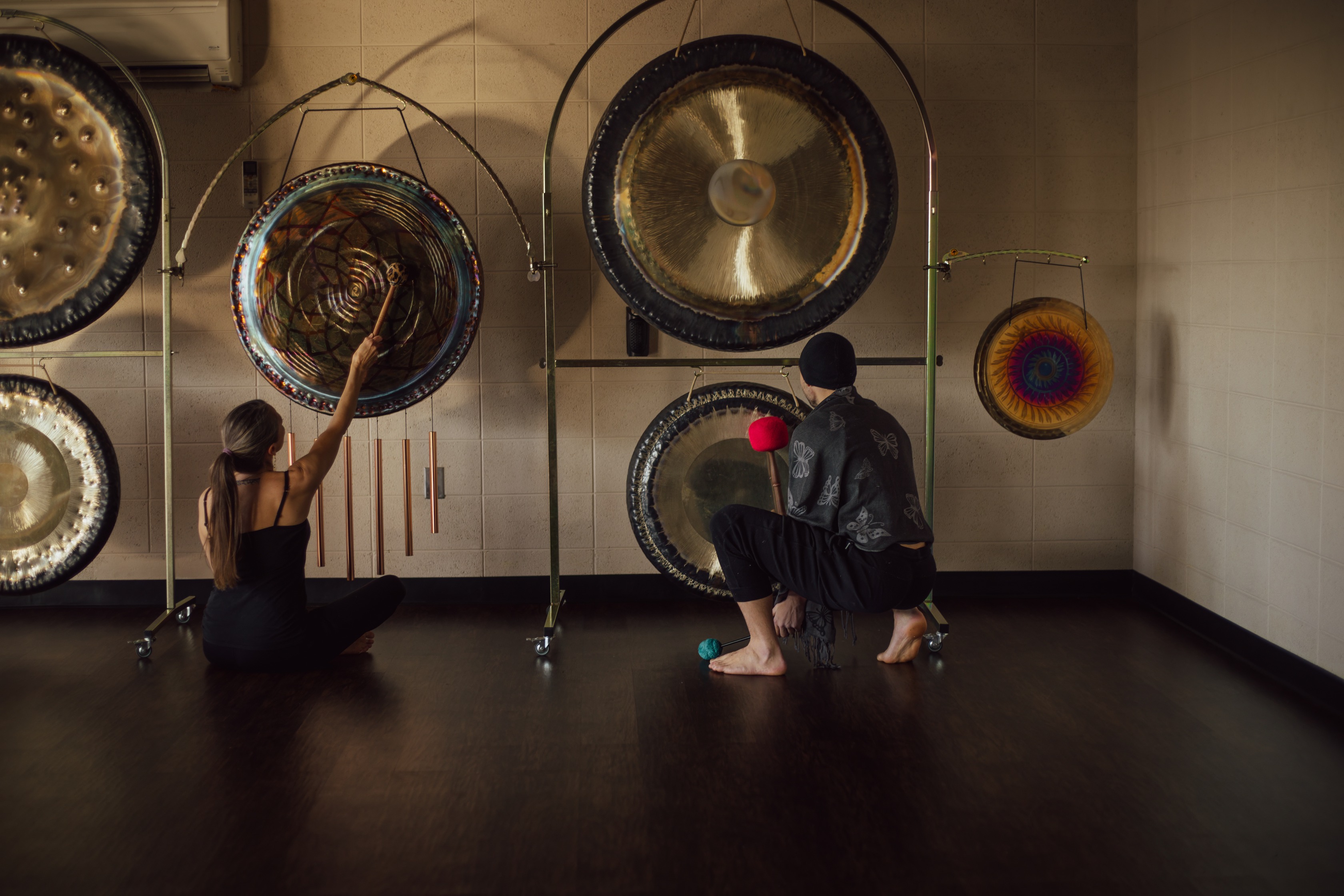 a man and woman playing gongs