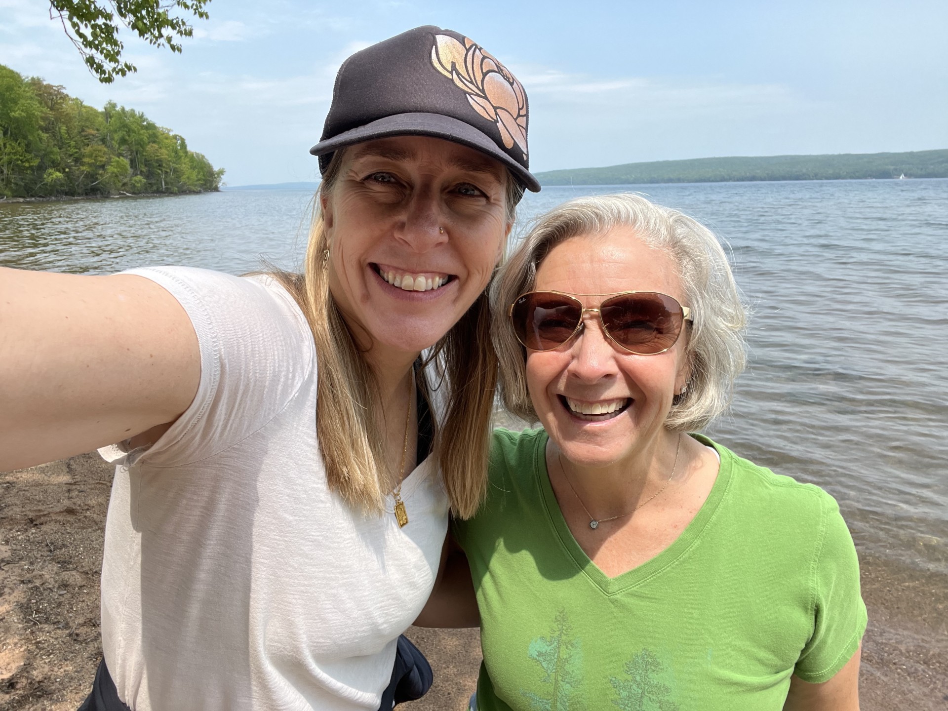 two women taking a selfie by a body of water