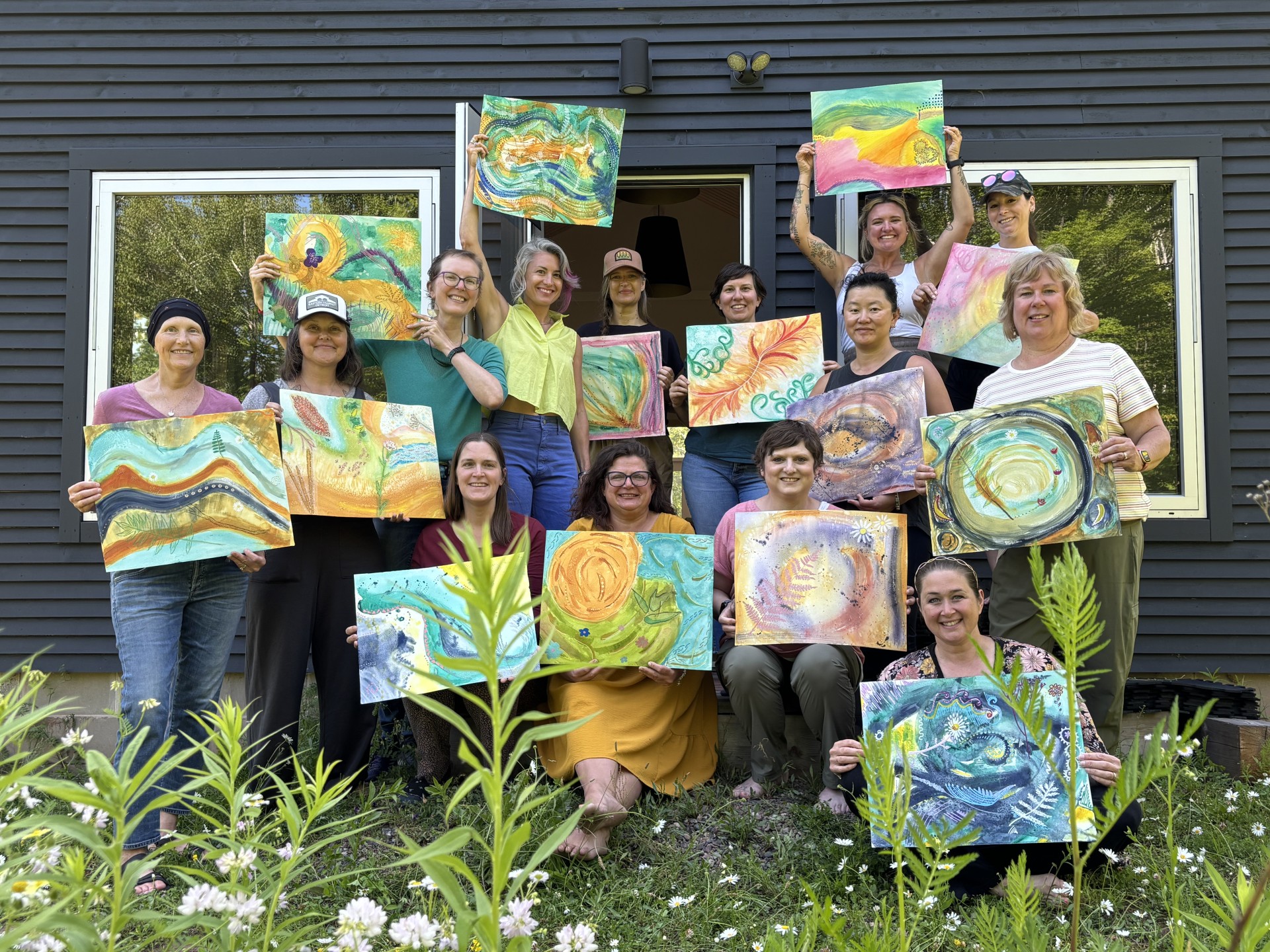 a group of people holding up paintings