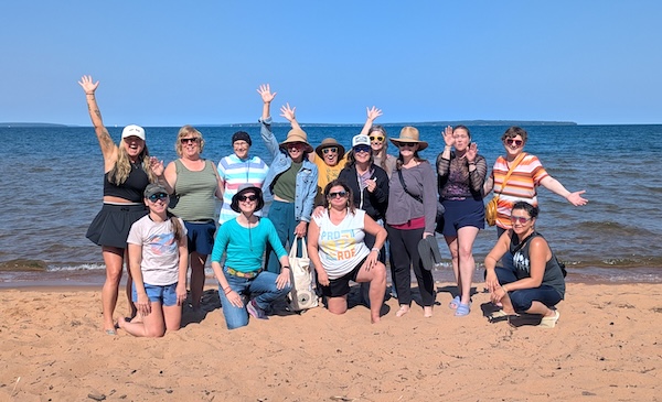 a group of people posing for a photo on a beach