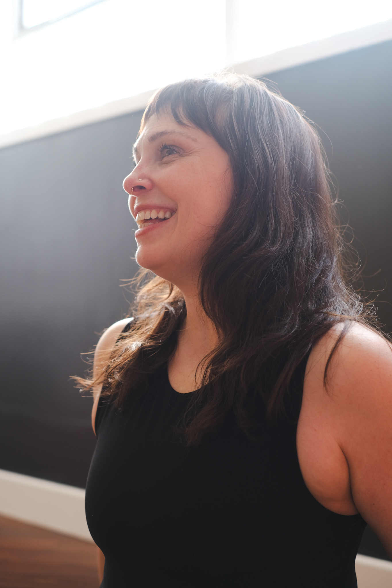 a woman smiling in a black tank top