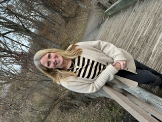 a woman standing on a wooden bridge
