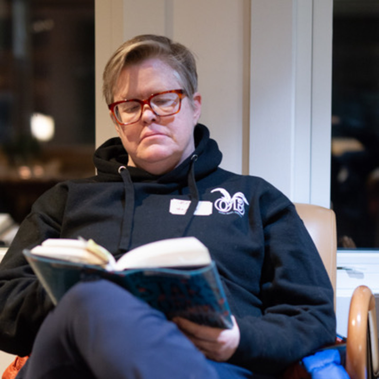 a woman sitting in a chair reading a book