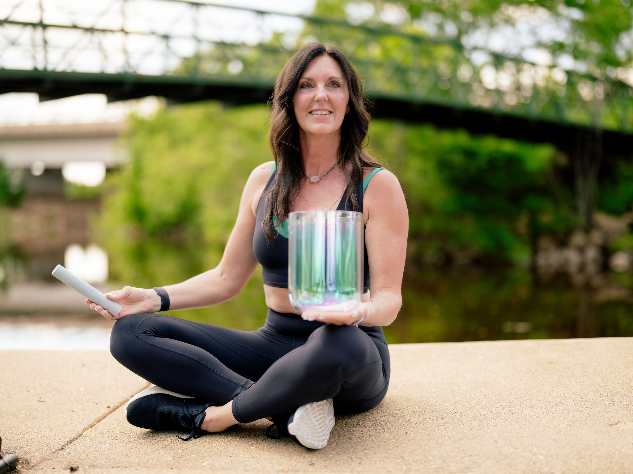 a woman sitting cross legged with a glass container