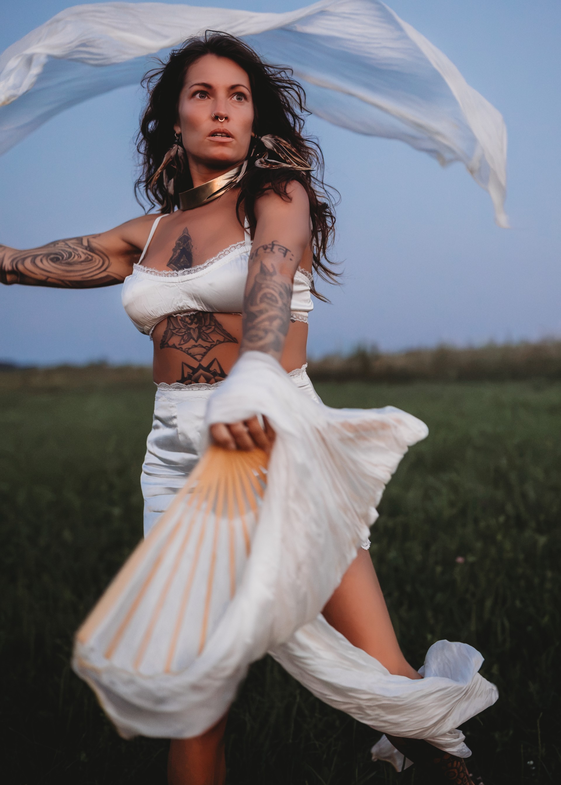 a woman in a field with a fan