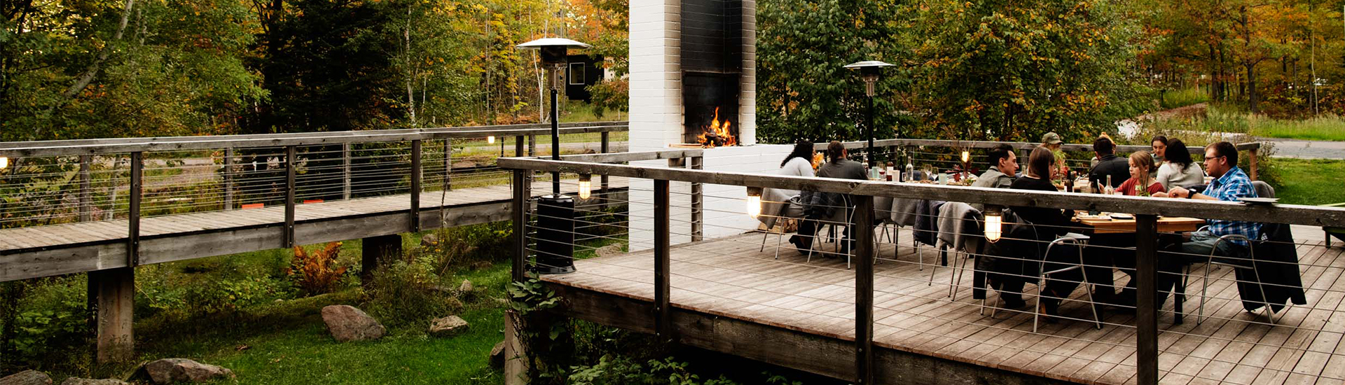 a couple sitting on a deck with a fire in the background
