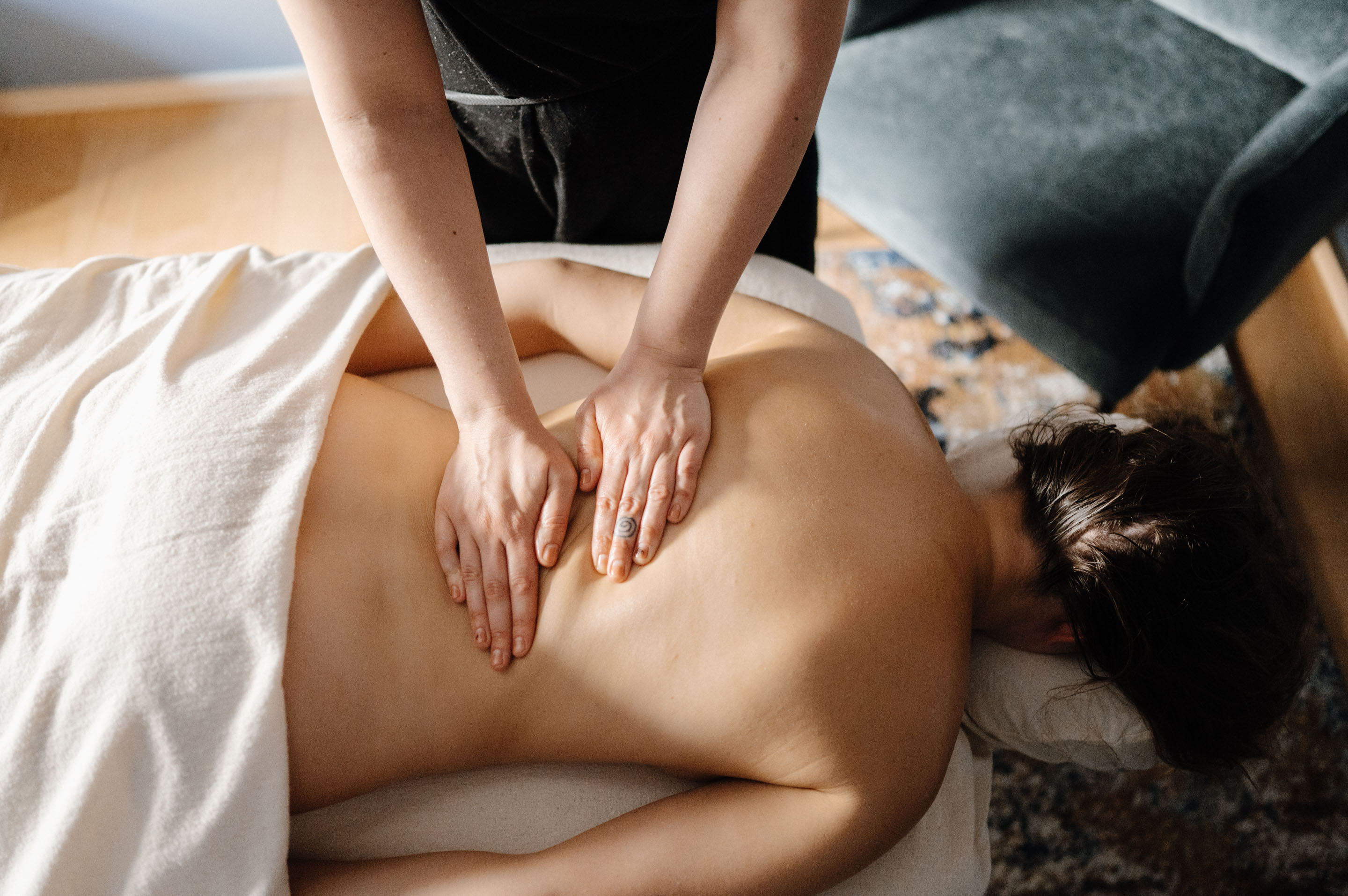a person massaging a woman's back