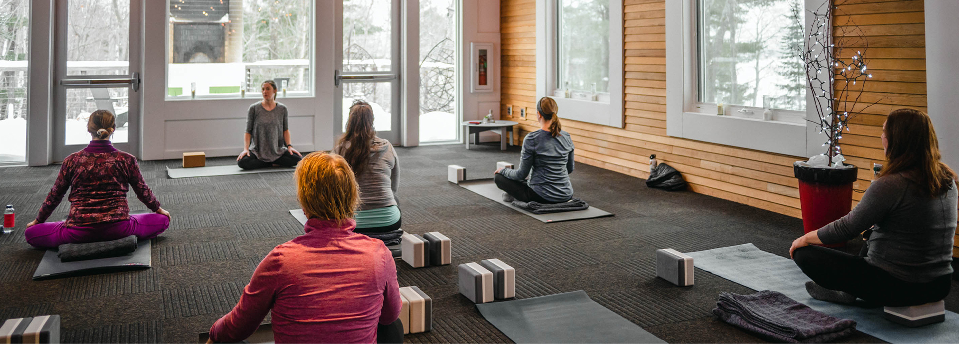 a group of people sitting on mats in a room