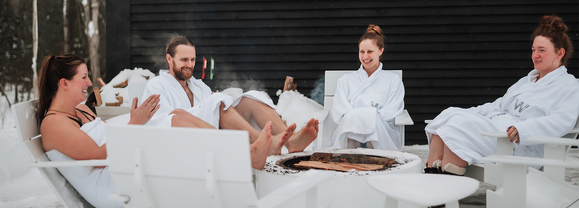 a group of people in white robes sitting around a fire pit